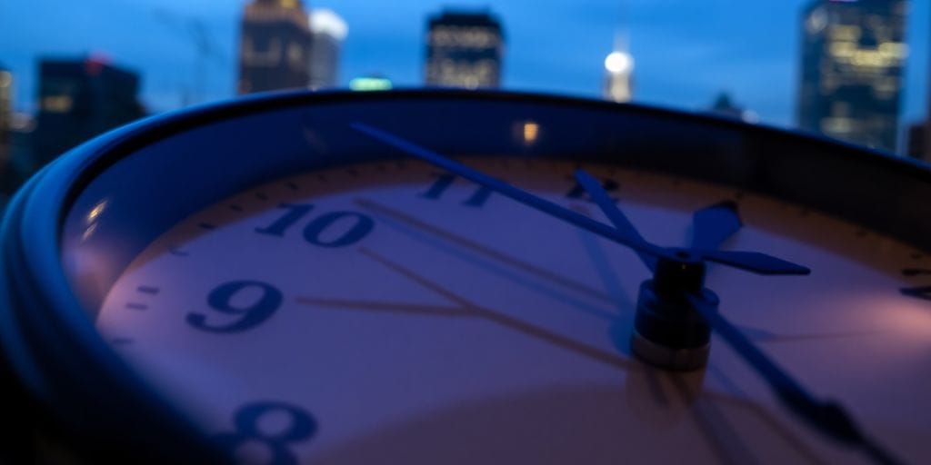 Clock face reflecting city lights at night.