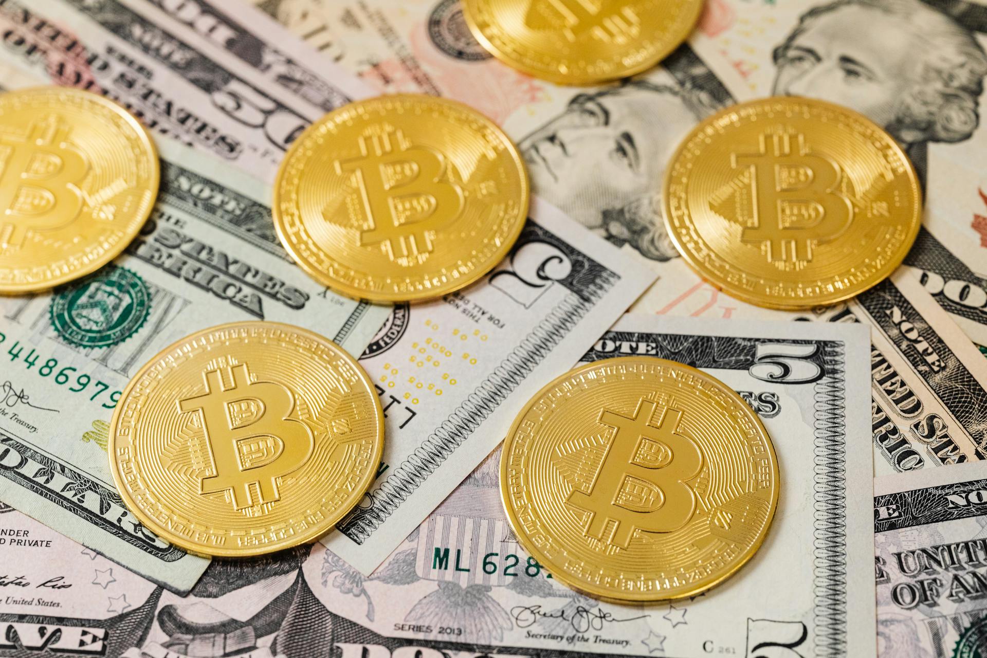 Bitcoin coins on dollar bills