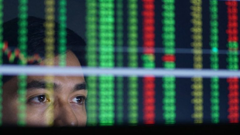 Forex trader's eyes reflecting currency exchange screens.