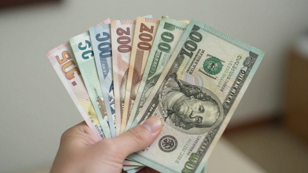 International currency bills held in hand